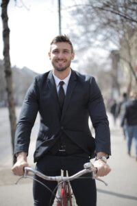 Man in pak op fiets onderweg naar werk