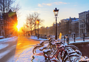 grachtenstraat met besneeuwde fietsen