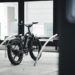Elektrische fiets op slot in een fietsenrek bij een modern gebouw, symbool voor het belang van fietsverzekering tegen diefstal.
