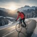 Fietser in winterlandschap rijdt op een bergweg door besneeuwde bergen als voorbereiding op het nieuwe fietsseizoen