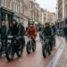 Fatbikes rijden tussen andere fietsers in een drukke Nederlandse winkelstraat met voetgangers.