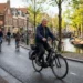 Oudere man fietst op elektrische fiets door druk Nederlands stadscentrum langs kanaal