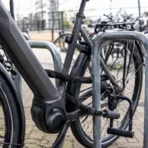 Elektrische fiets met twee sloten vastgezet aan een fietsenrek als bescherming tegen diefstal.